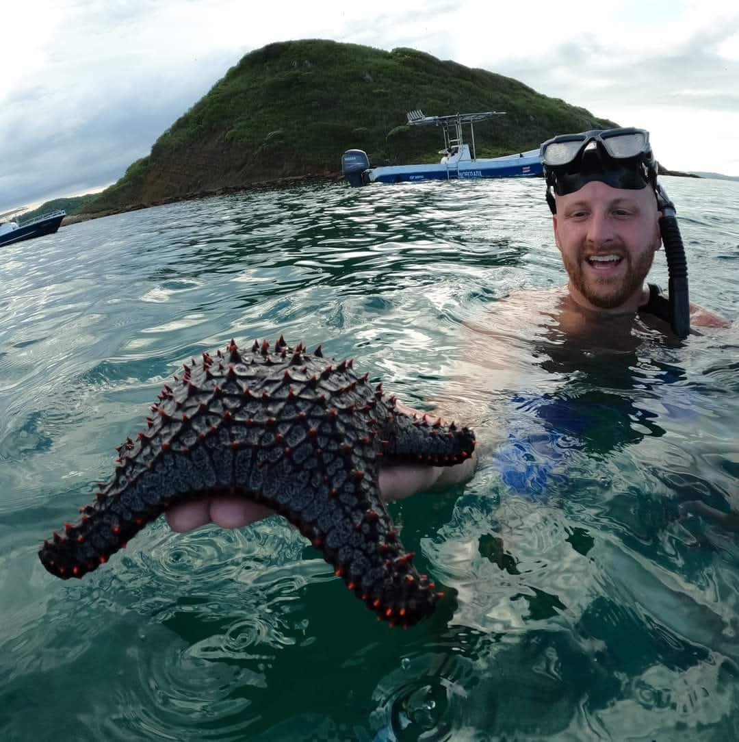 Snorkeling guest with sea star at Santa Elena Bay Costa Rica
