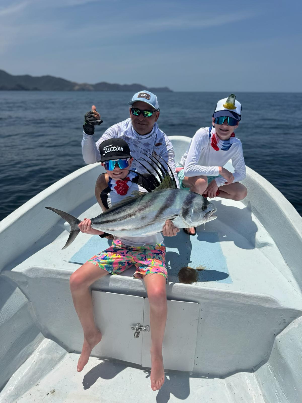Kids with roosterfish on family fishing charter