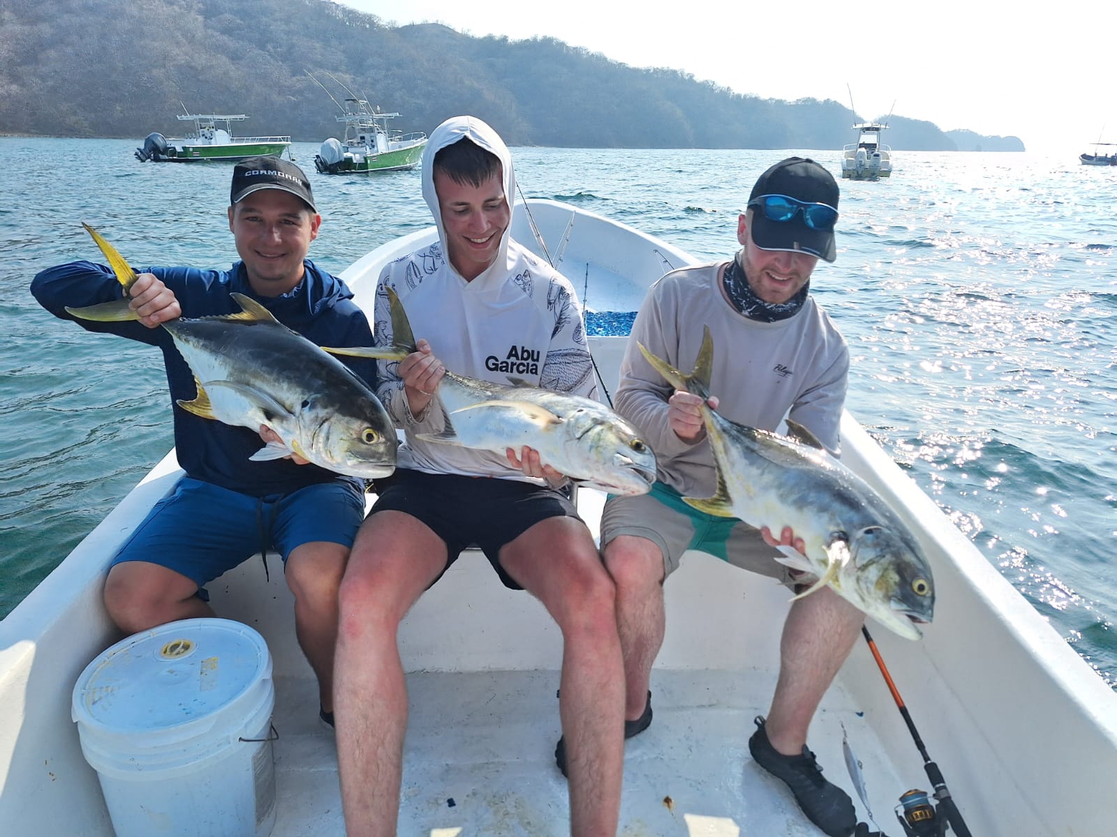 Three friends with yellowtail jacks on charter